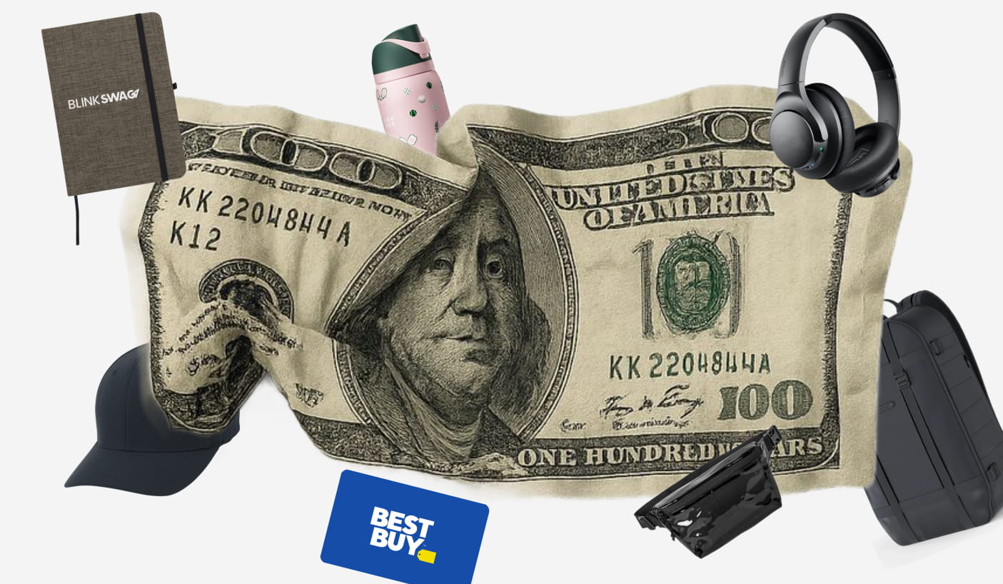 One-hundred-dollar bill surrounded by custom corporate gifts including a notebook, tumbler, headphones, and bag.